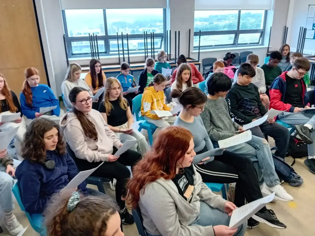 Choir rehearsal with students holding music sheets